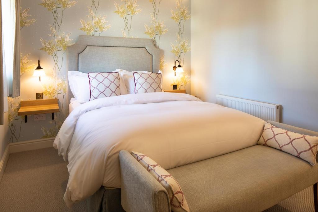 a bedroom with a large bed and a couch at The Inn West End in Woking