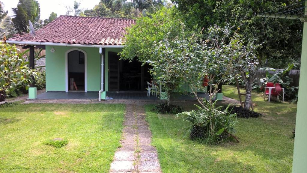 a small green house with a pathway leading to it at Casa, quarto inteiro e quarto compartilhado Juréia in Juréia