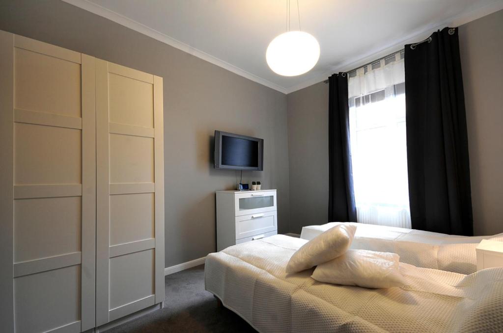 een slaapkamer met een bed, een tv en een raam bij Jazzgot Apartamenty in Zielona Góra