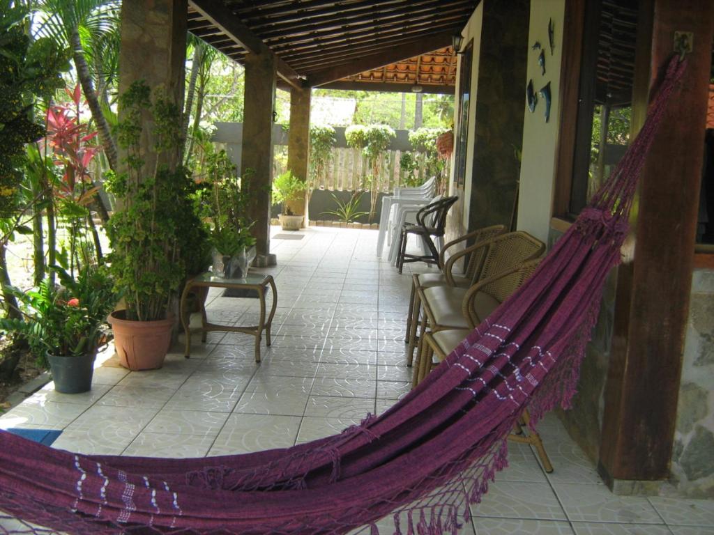 a hammock on the porch of a house at Casa de praia itacimirim in Itacimirim