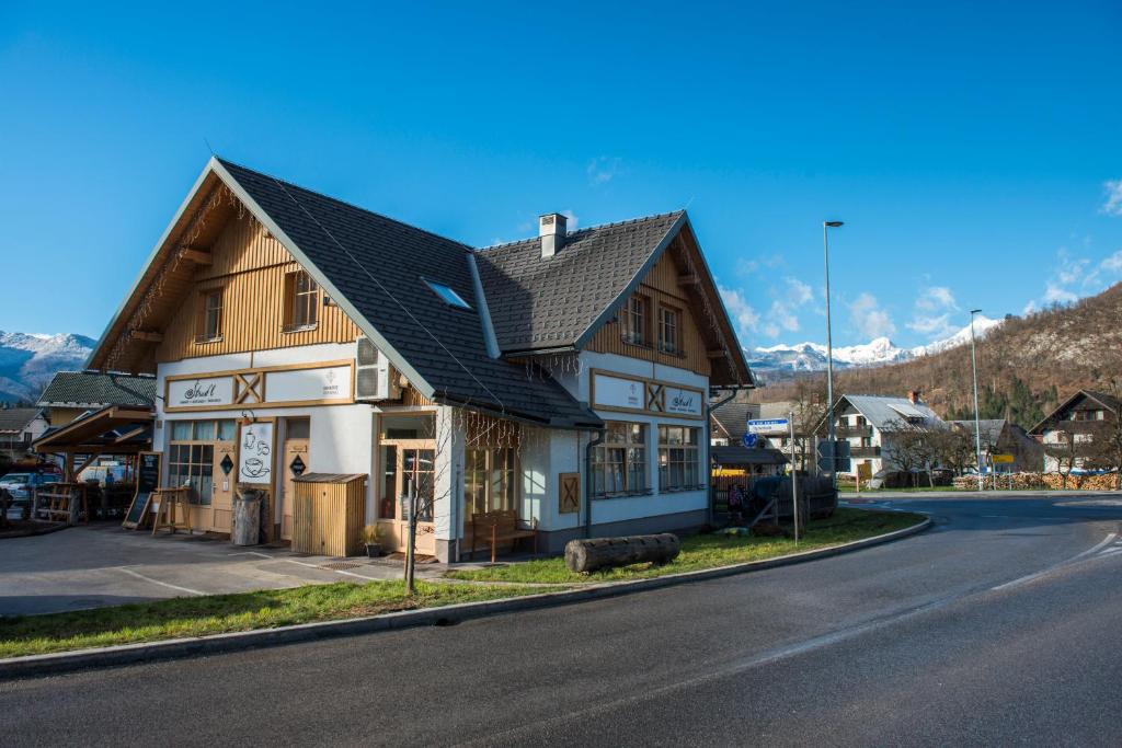 a house on the side of a road with a mountain at Apartmaji Štrud´l Bohinj in Bohinj