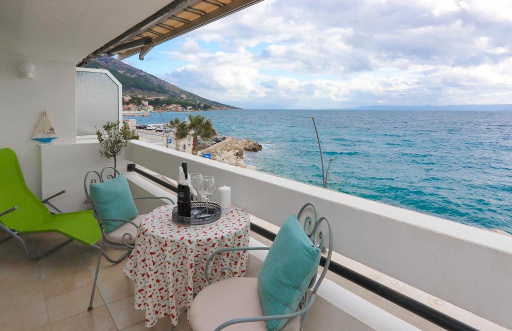 een balkon met een tafel en stoelen en de oceaan bij Amazing Waterfront Apartments in Bol