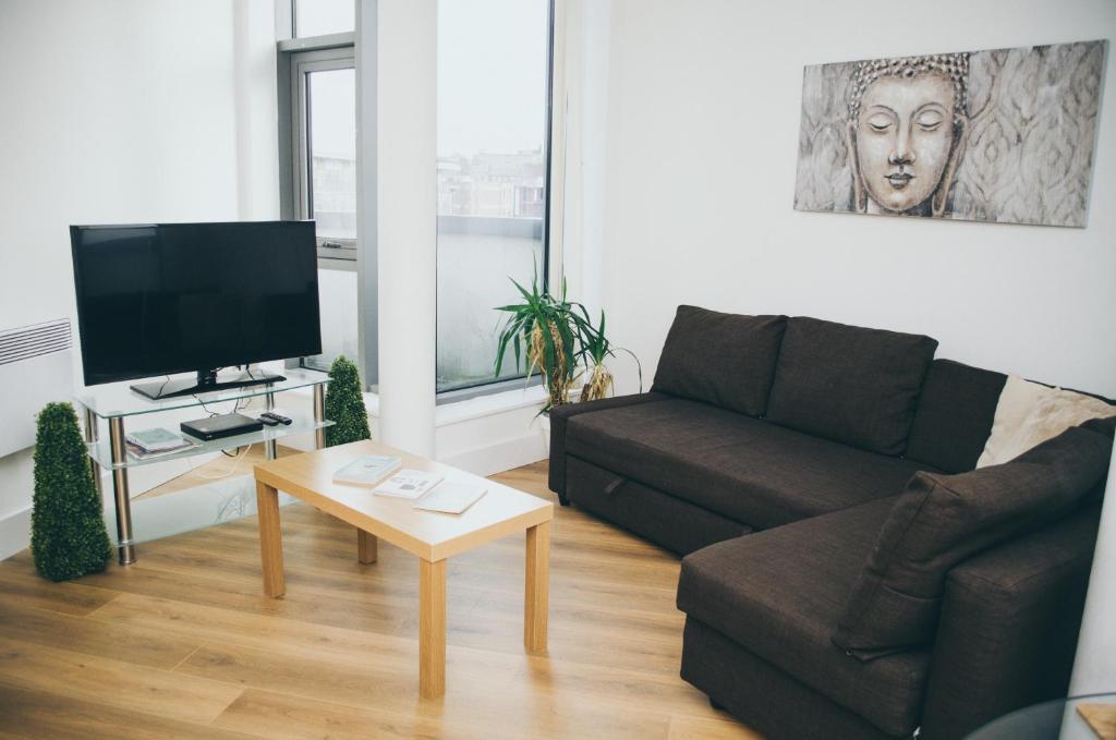 uma sala de estar com um sofá e uma mesa de centro em Serviced Apartment In Liverpool City Centre - Free Parking - Balcony - by Happy Days em Liverpool