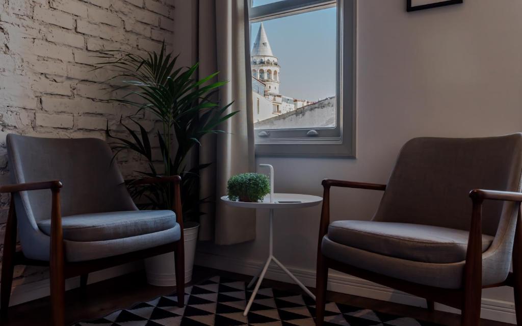 2 sillas y una mesa en una habitación con ventana en HAUS Suites Galata, en Estambul