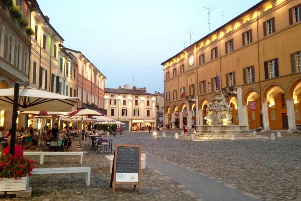 a city street with buildings and a sign in the middle at RESIDENZA LEON D'ORO in Cesena