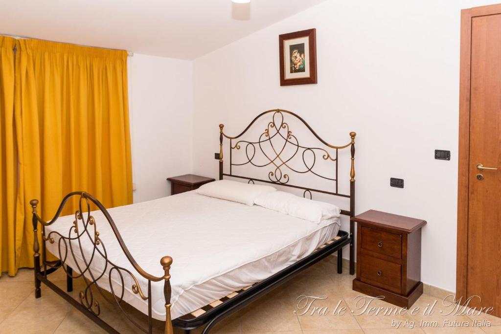 テルメ・ヴィリアトーレにあるTra le Terme e il Mareのベッドルーム(ベッド1台、黄色のカーテン付)