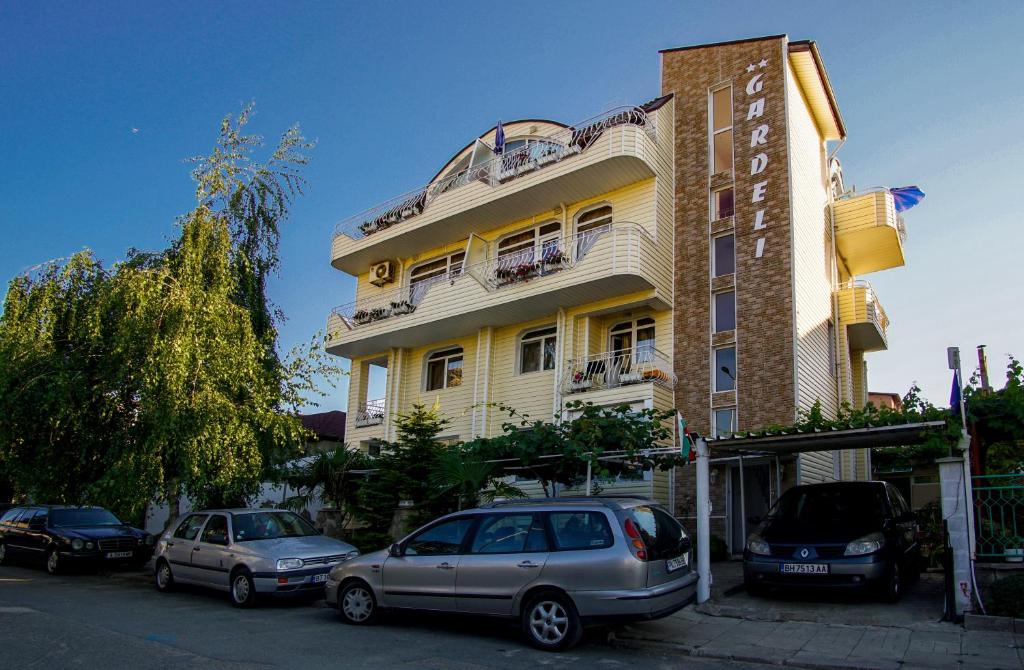 een gebouw waar auto's voor geparkeerd staan bij Guest House Gardeli in Tsarevo