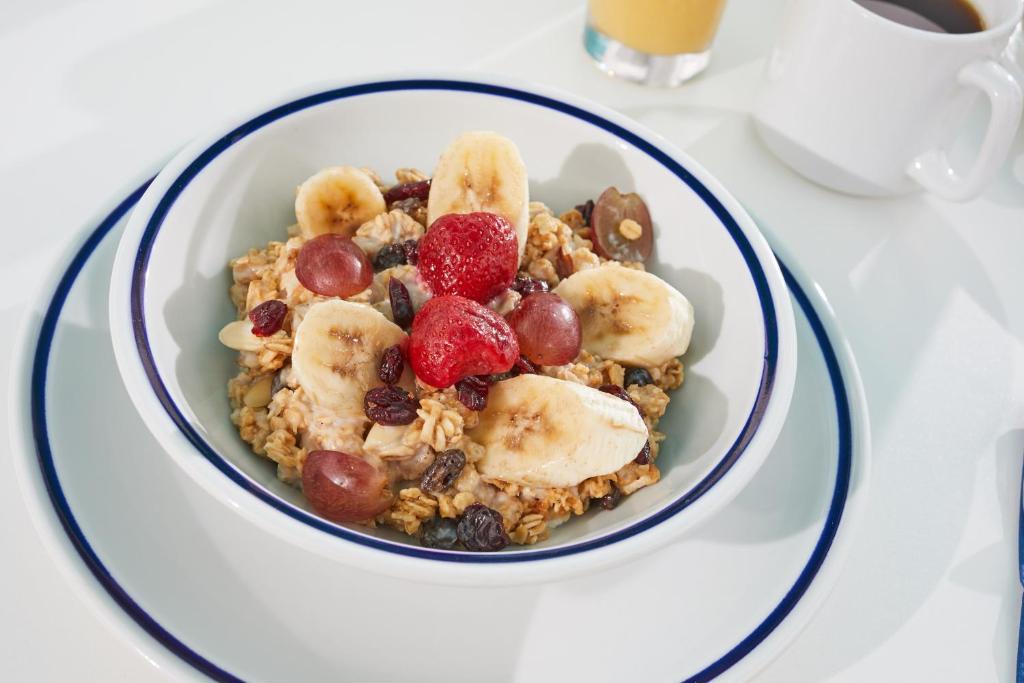 a bowl of cereal with bananas and fruit on it at Beach View Hotel in Saint James