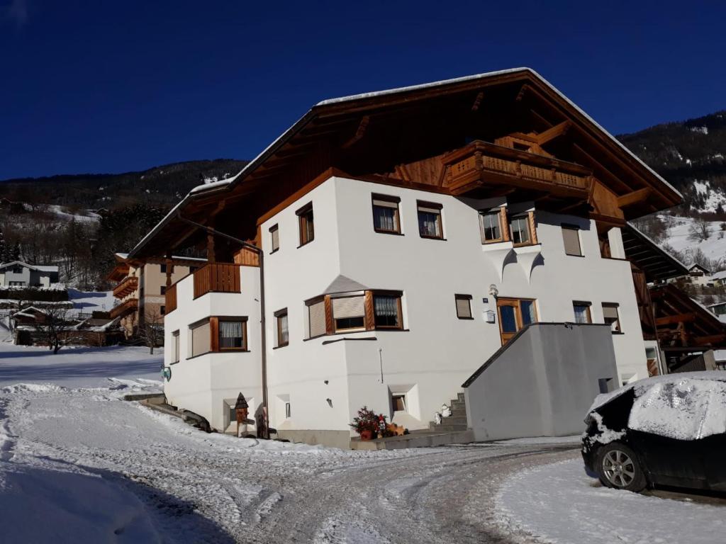 a house in the snow with a car parked in front at Ferienwohnung Lechthaler Andrea in Wenns