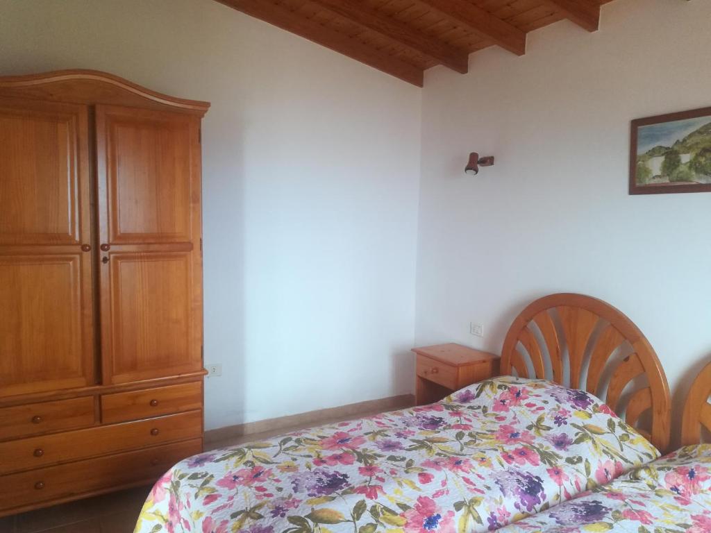 EchedoにあるVivienda Vacacional El Luceritoのベッドルーム1室(ベッド1台付)、木製キャビネットが備わります。