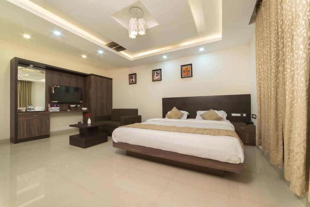 Hotel Sami V Landmarks في Arantāngi: غرفة نوم بسرير وكرسي وتلفزيون