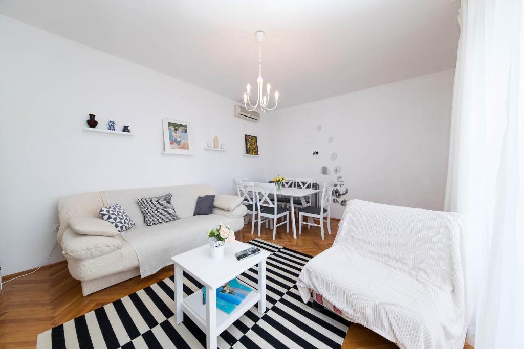 Biały salon z białą kanapą i stołem w obiekcie Apartmani Ružica w Crikvenicy