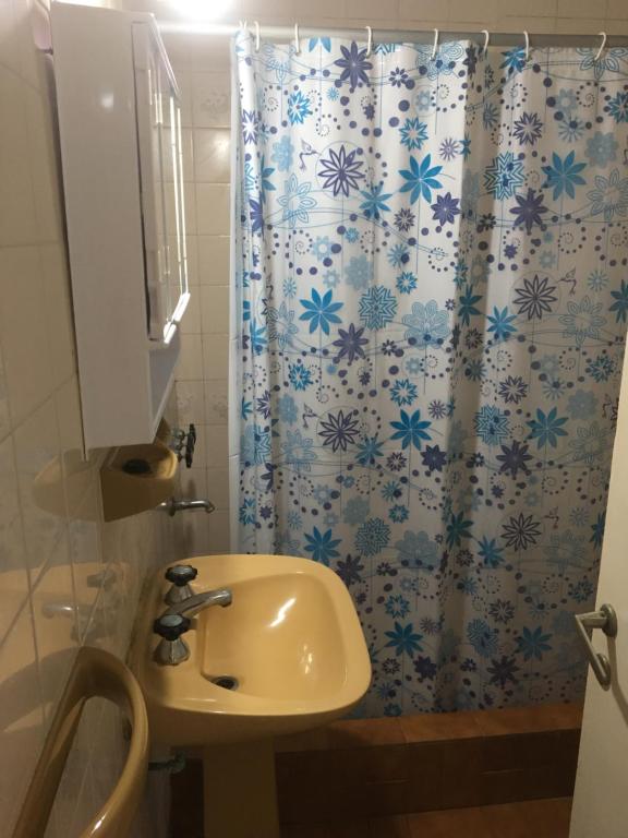 a bathroom with a shower curtain with a sink at Sol y Arena Plaza in San Clemente del Tuyú