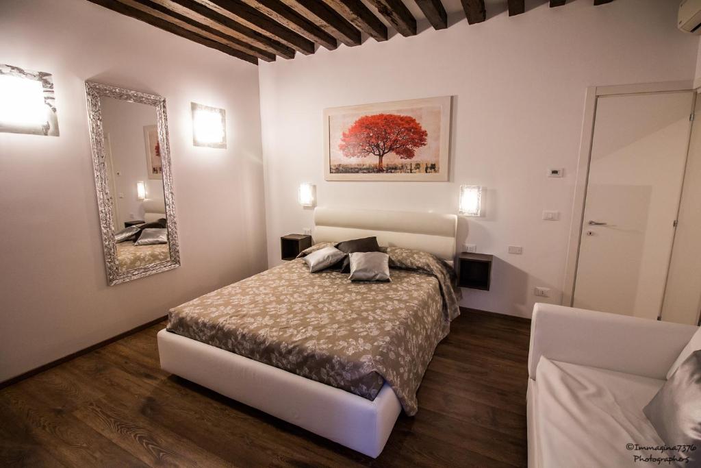 sypialnia z łóżkiem i lustrem w obiekcie Silver Suite w Wenecji