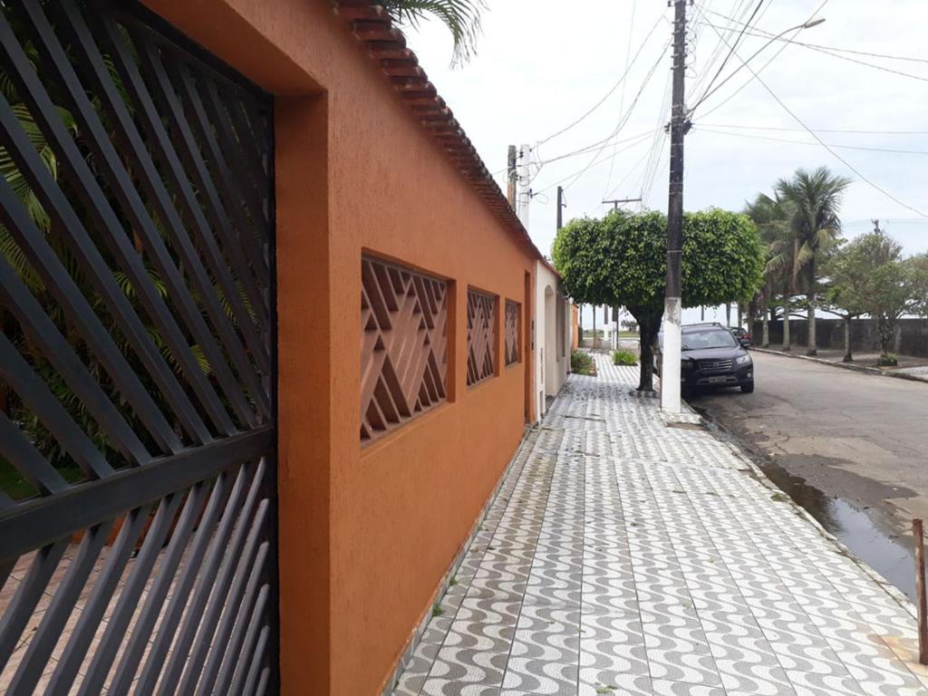 um edifício laranja com cartazes ao lado de uma rua em Casa a 50 Metros da Praia - No melhor local da PG na Praia Grande