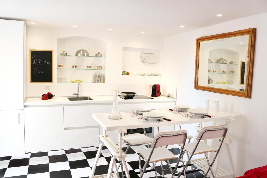 a kitchen with a white counter and a table and chairs at Dolce Loft in Bari