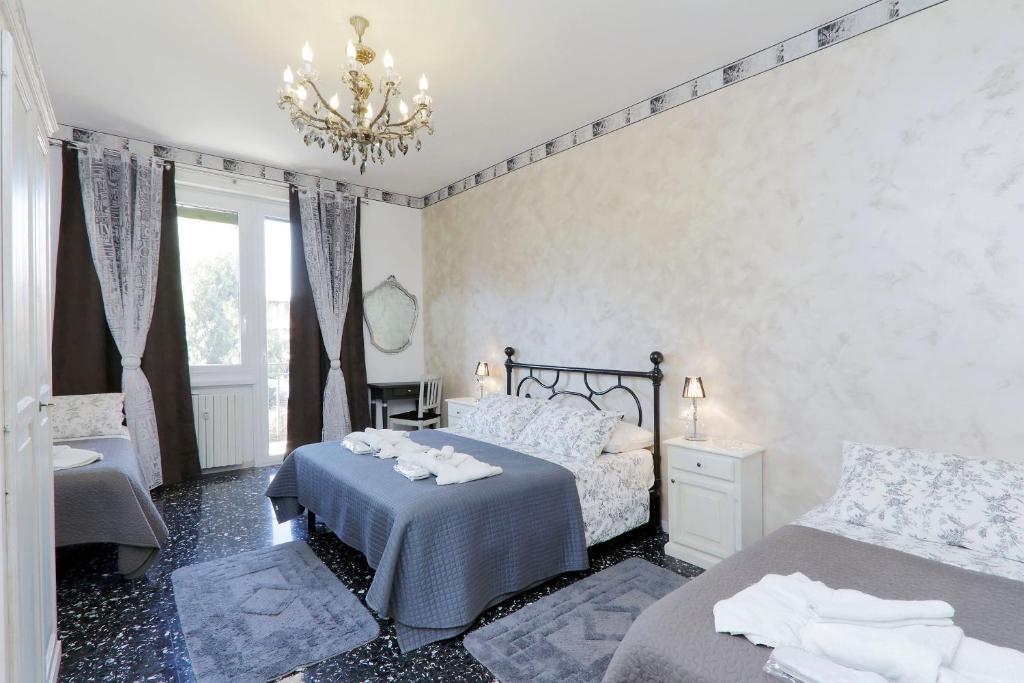 1 dormitorio con 2 camas y lámpara de araña en Appartaments Marrucini, en Roma