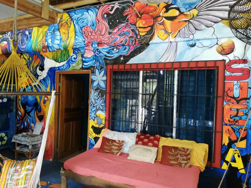 a room with a colorful wall with a bench in front at Cliff's Hostel in La Gruta