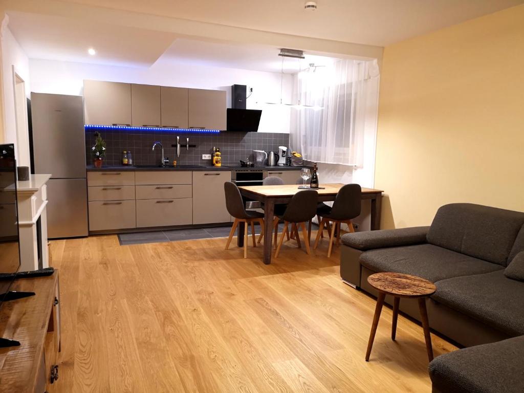 a kitchen and a living room with a table and chairs at Family Suites & Parking in Baden-Baden