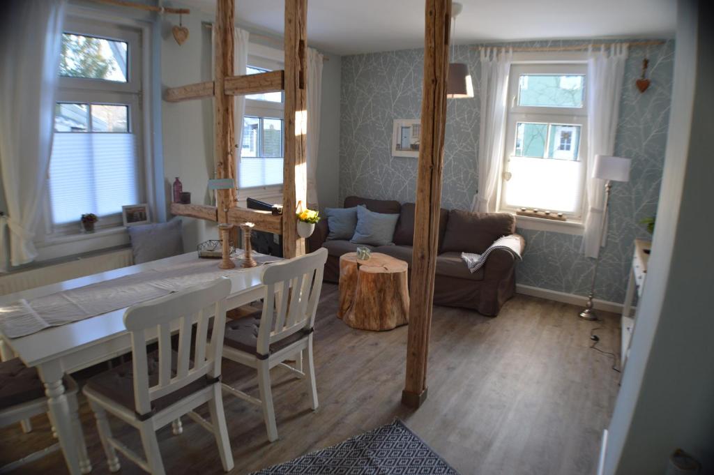 uma sala de estar com uma mesa e cadeiras e um sofá em Ferienwohnung "Auszeit" em Tabarz