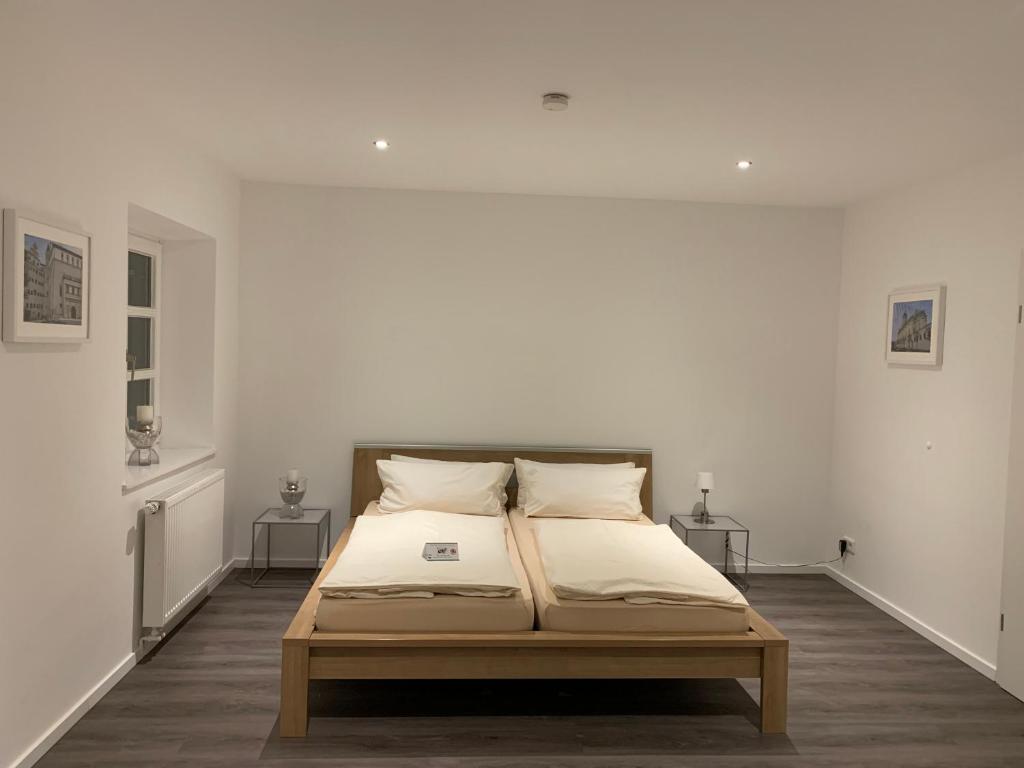 a bed in a room with white walls at Zentrum Appartment Neuburg in Neuburg an der Donau