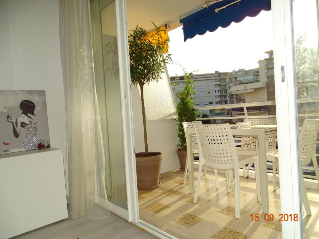 a dining room with a table and chairs on a balcony at Palm beach Cannes Azur in Cannes