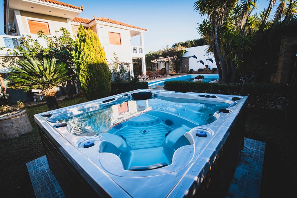 a blue hot tub in a yard next to a house at Villa Soula in Anavissos