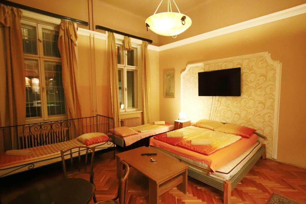 a bedroom with two beds and a tv on the wall at Central Apartments of Budapest in Budapest