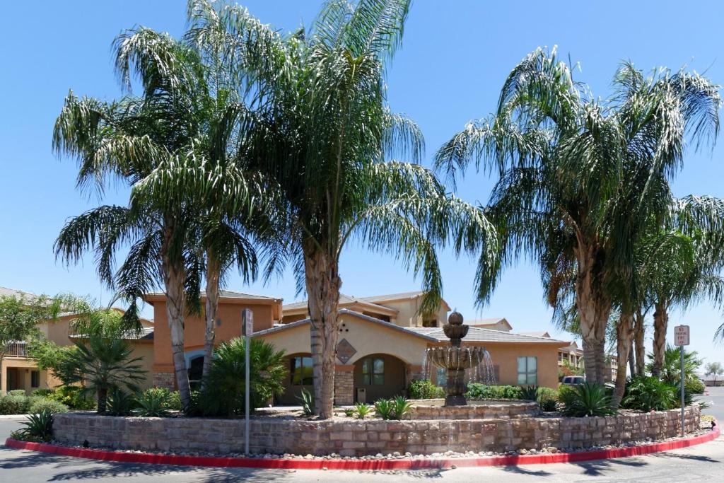 a house with palm trees in front of it at Siegel Select Casa Grande in Casa Grande
