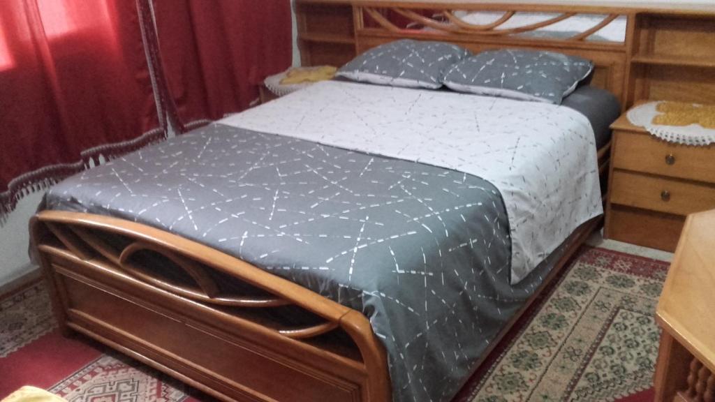 - une chambre avec un lit doté d'un cadre en bois dans l'établissement Garçonnière privée à rabat, à Rabat