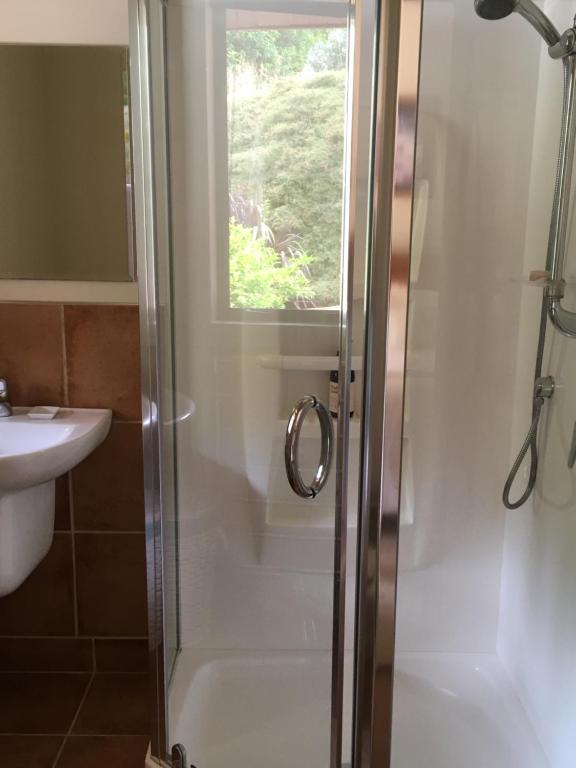 a bathroom with a shower and a sink at Bush Line Lodge in Motueka