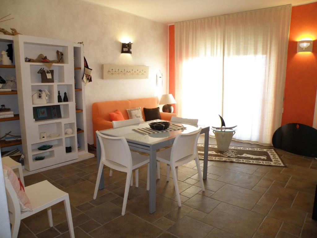 - un salon avec une table et des chaises blanches dans l'établissement Le Stanze di Patika, à Tortolì