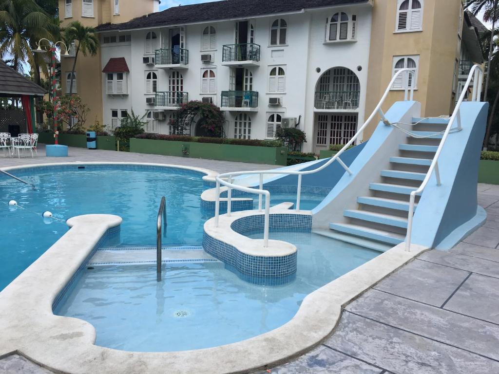 una piscina con un tobogán frente a un edificio en Castle by the Shore, en Ocho Ríos