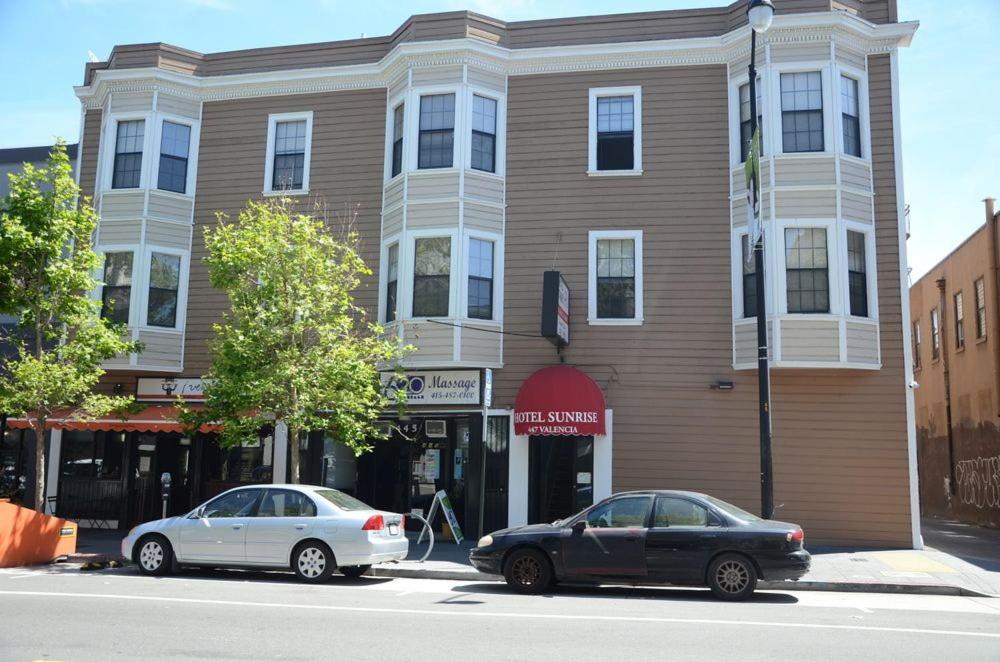 two cars parked in front of a building at Hotel Sunrise in San Francisco