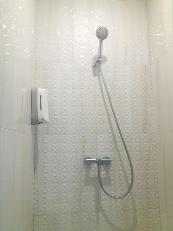 una doccia in bagno con asciugacapelli a parete di Hotel Shakti Capsule a Bandung