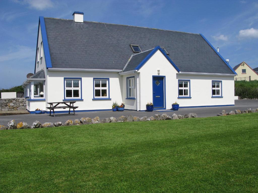 una casa bianca con una porta blu e un cortile di Nellie Dee's - Room Only a Doolin