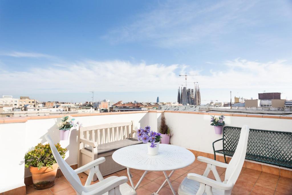eine Terrasse mit einem Tisch und Stühlen auf dem Balkon in der Unterkunft Sagrada Familia Attic - Terrace Bcn Views in Barcelona