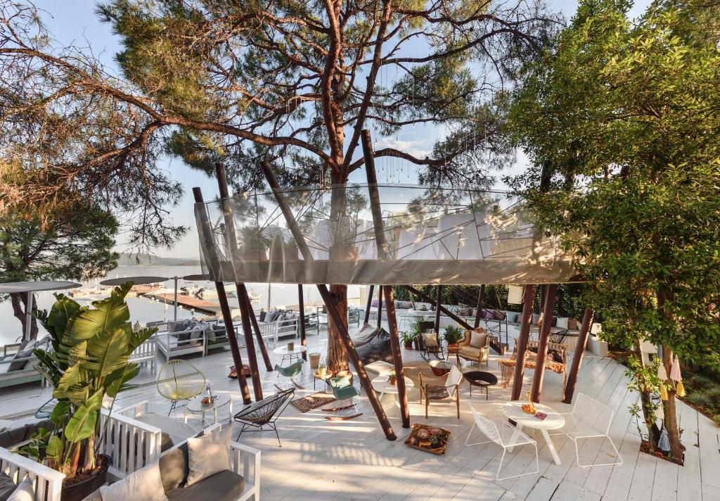 a patio area with tables, chairs and umbrellas at Ekies All Senses Resort in Vourvourou