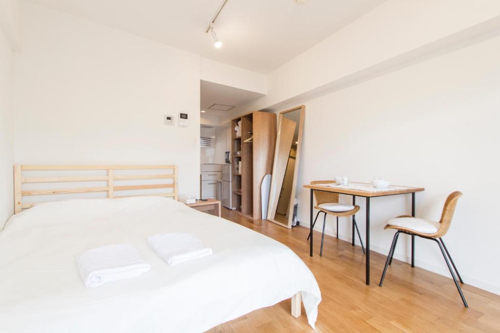 a bedroom with a bed and a table and chairs at Dwell Urban 7B in Tokyo