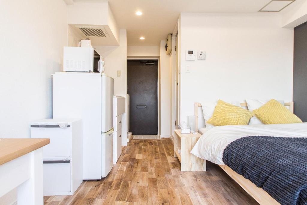 a bedroom with a white refrigerator and a bed at Dwell Urban 6D in Tokyo