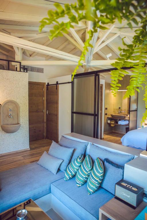 a living room with a blue couch with pillows at Ekies All Senses Resort, a Member of Design Hotels in Vourvourou