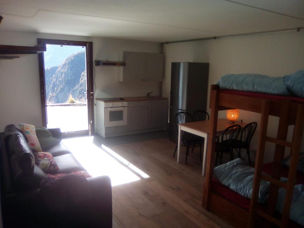 ein Wohnzimmer mit einem Sofa und einem Tisch sowie eine Küche in der Unterkunft Appartment Emosson 2 in Finhaut