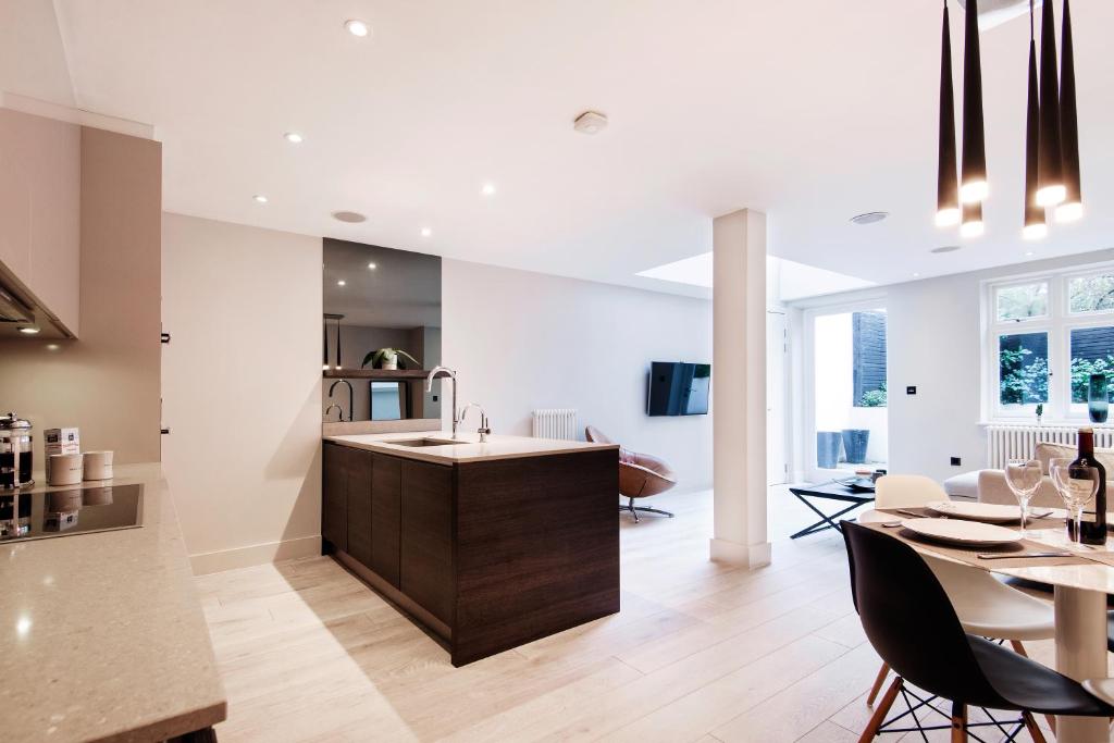 uma cozinha e sala de jantar com um lavatório e uma mesa em Home Sweet Hampstead Heath em Londres