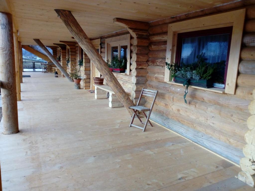 een houten veranda van een blokhut met een stoel bij Reiterhof Mühlbauer in Grattersdorf