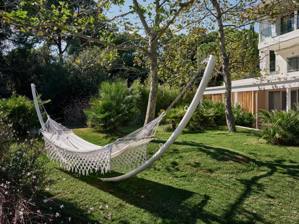 a hammock in a garden in a yard at Ekies All Senses Resort, a Member of Design Hotels in Vourvourou