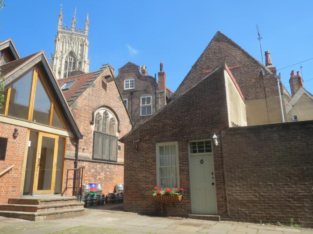 an old brick house with a clock tower in the background at Trembling Madness Apartments in York