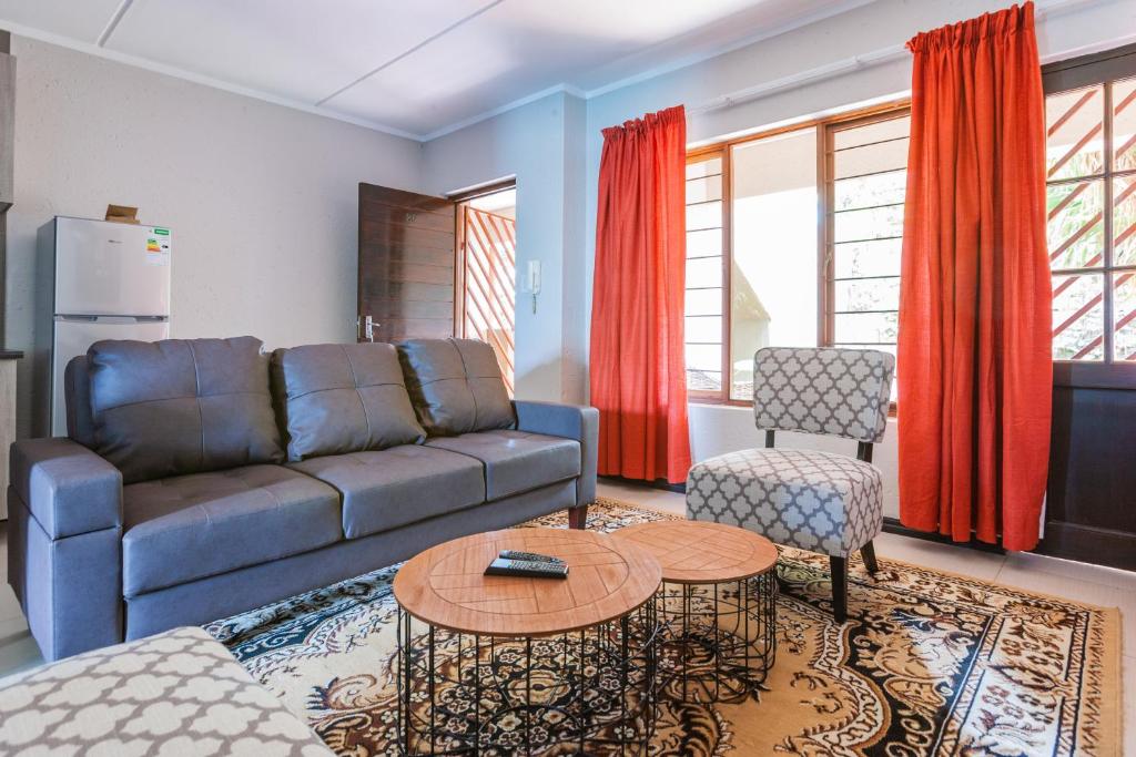 una sala de estar con un sofá y una mesa en Alimama Spaces: Manson's Bedford Haven, en Johannesburgo
