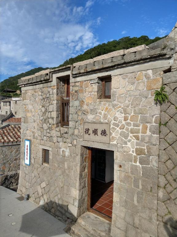 a stone building with a sign in front of it at 芹壁德順號民宿Chinbe D S House B&B in Beigan