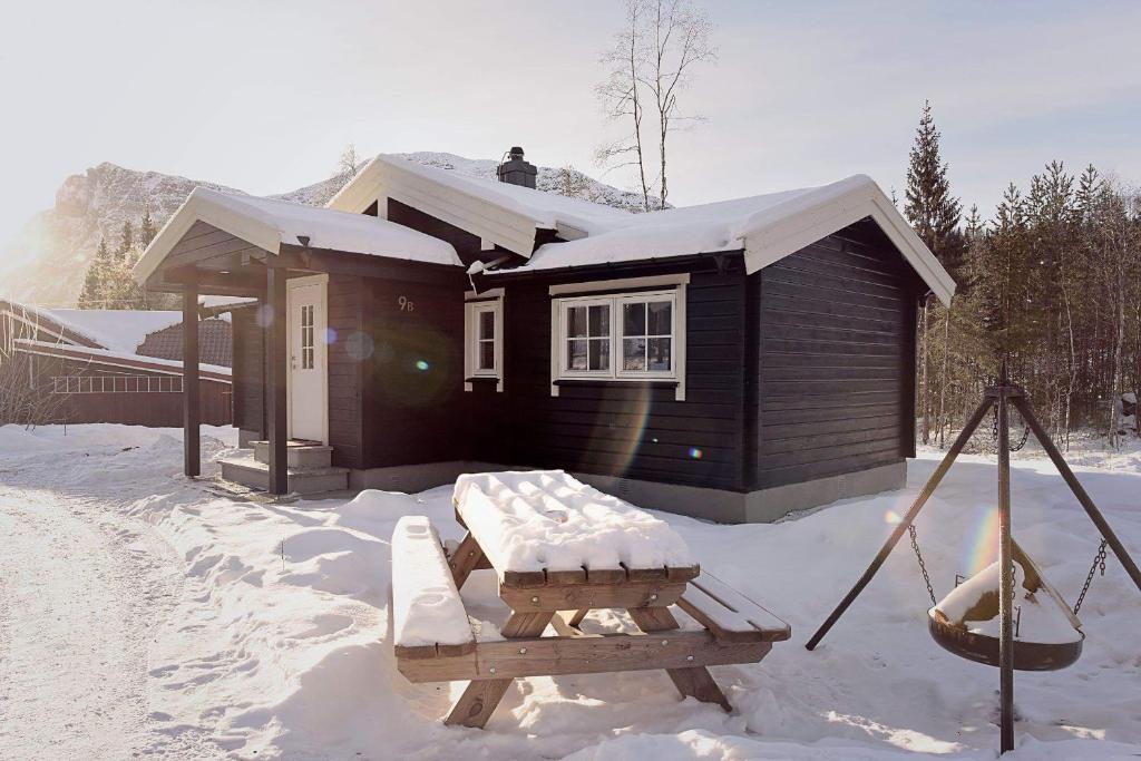 a cabin with a picnic table in the snow at Fresh Familie Hytte Hemsedal in Hemsedal