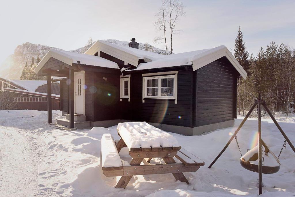 a cabin with a picnic table in the snow at Fresh Familie Hytte Hemsedal with Outdoor Sauna in Hemsedal